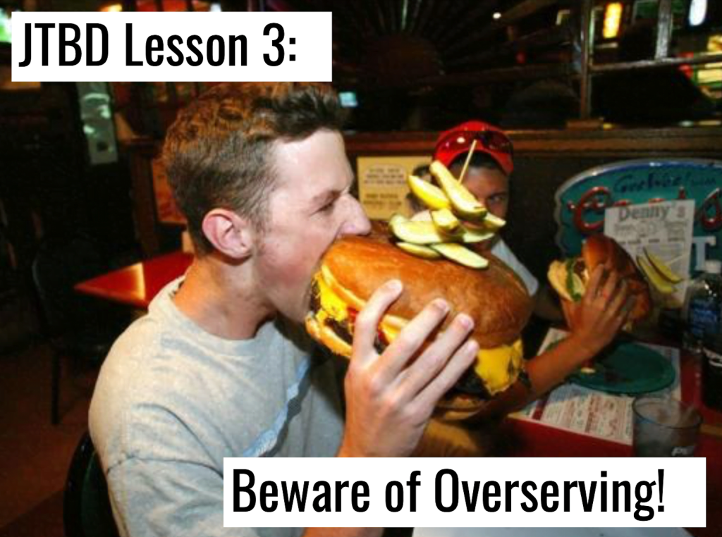 person attempting to eat a giant burger that is twice the size of their head